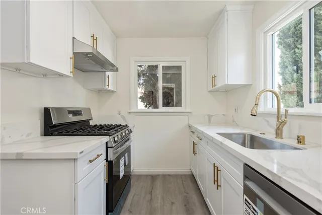 a kitchen with stainless steel appliances granite countertop a sink stove and cabinets