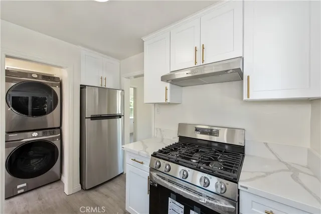 a kitchen with stainless steel appliances granite countertop a stove a refrigerator and a sink