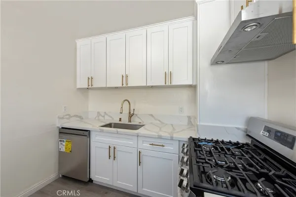 a kitchen with stainless steel appliances granite countertop a sink stove and cabinets