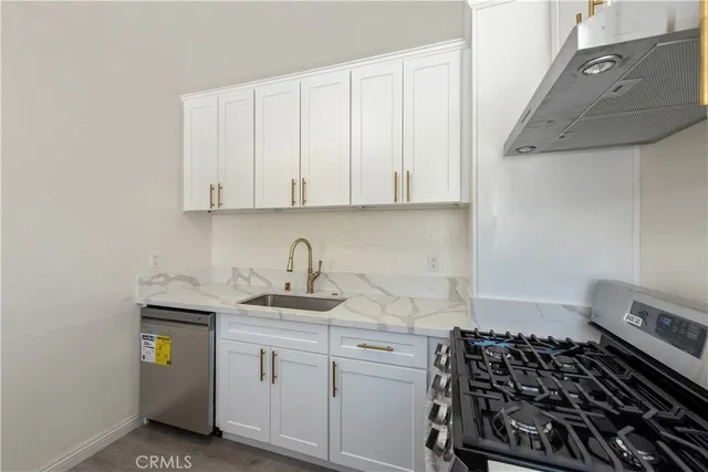 a kitchen with stainless steel appliances granite countertop a sink stove and cabinets