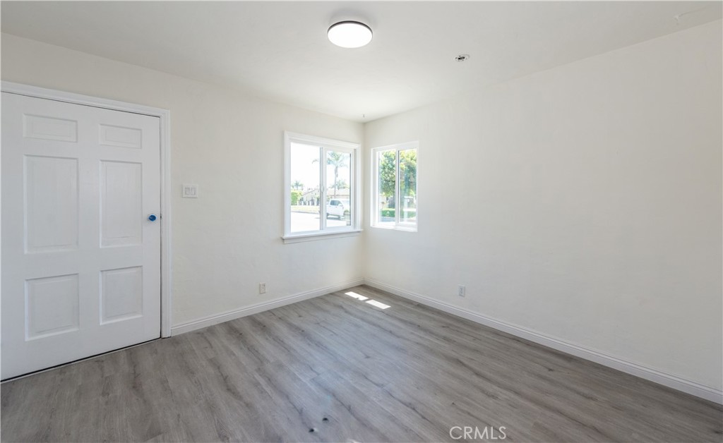 8713 Alondra Boulevard Paramount, CA 90723 - Photo 3 of 41 an empty room with wooden floor and windows