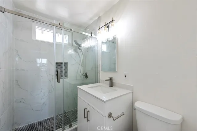 a bathroom with a sink a toilet and shower