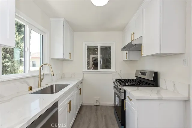 a kitchen with a sink a stove a microwave and cabinets