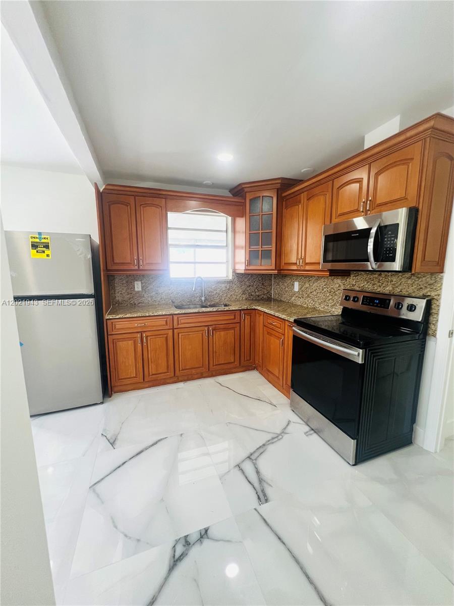 15530 Southwest 295th Terrace Homestead, FL 33033 - Photo 1 of 14 a kitchen with stainless steel appliances granite countertop a stove a sink and a refrigerator