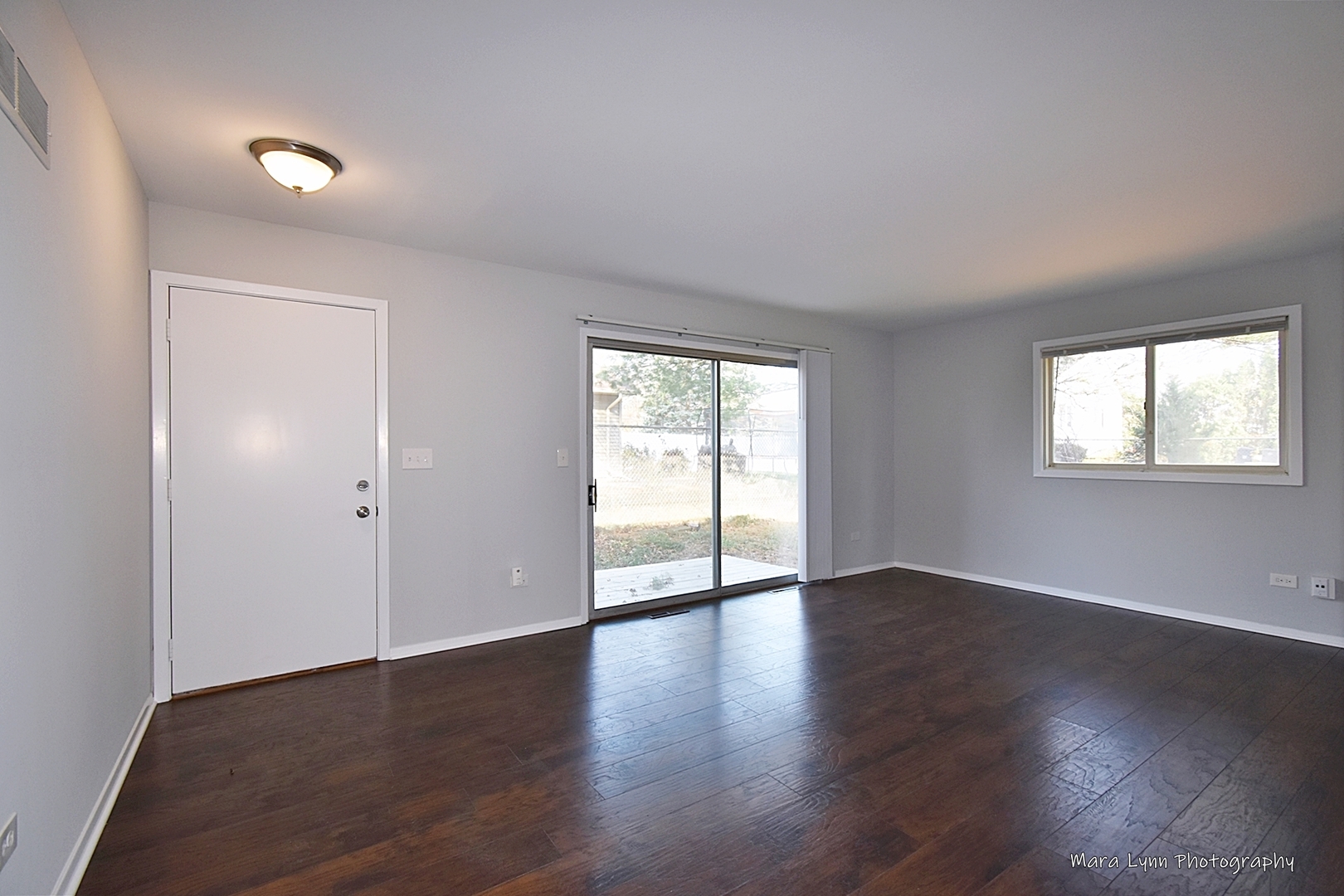 313 South Hawthorne Street Elgin, IL 60123 - Photo 2 of 22 an empty room with wooden floor and windows