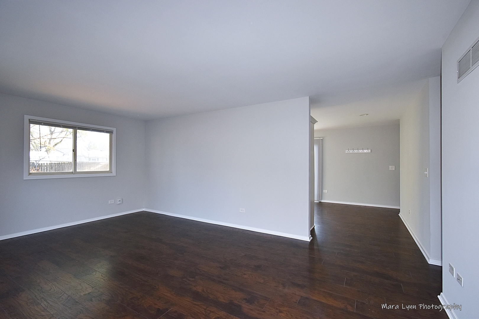 313 South Hawthorne Street Elgin, IL 60123 - Photo 6 of 22 a view of an empty room with wooden floor and a window