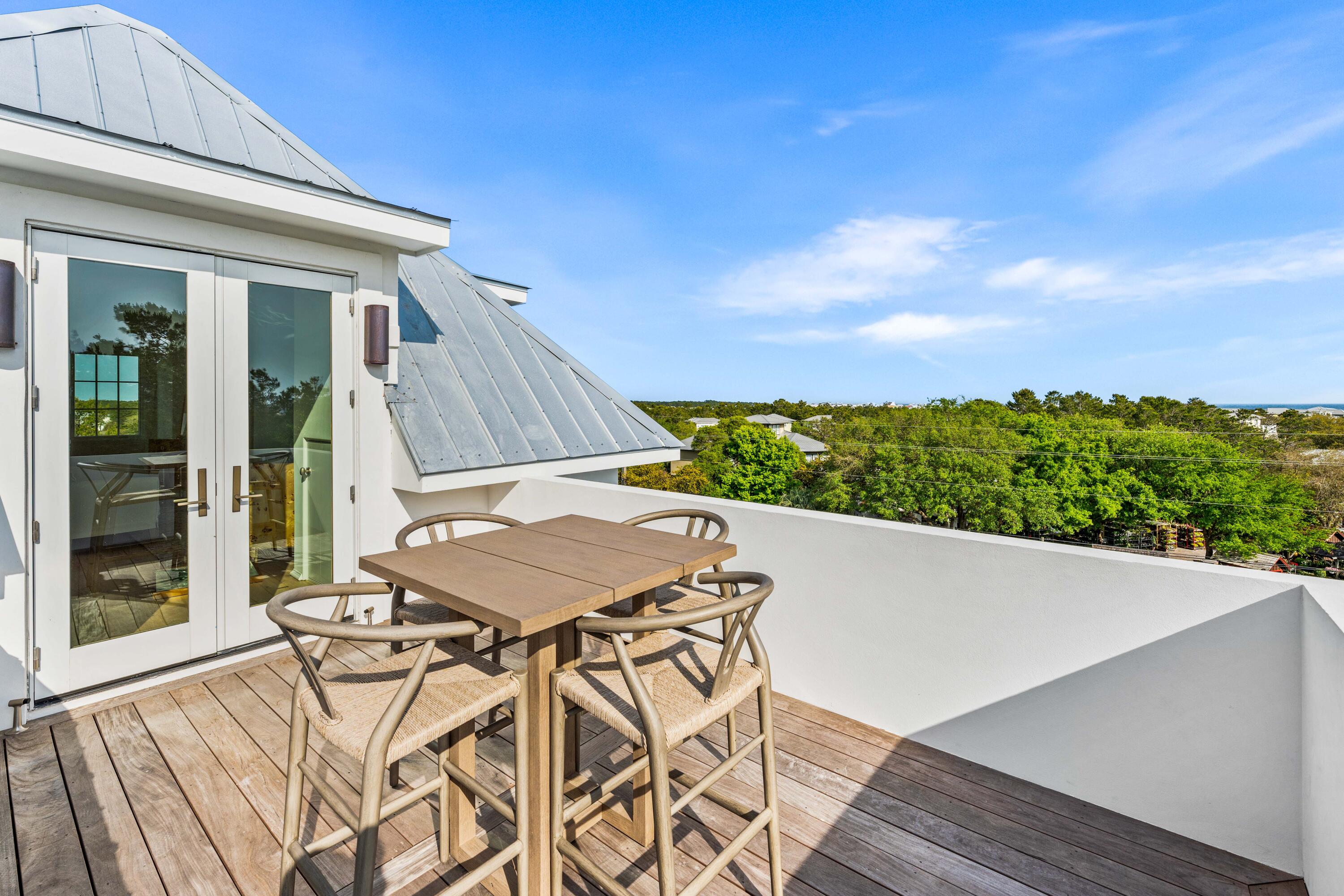 4655 East County Highway 30A Santa Rosa Beach, FL 32459 - Photo 49 of 69 a view of a patio with table and chairs with wooden floor and fence