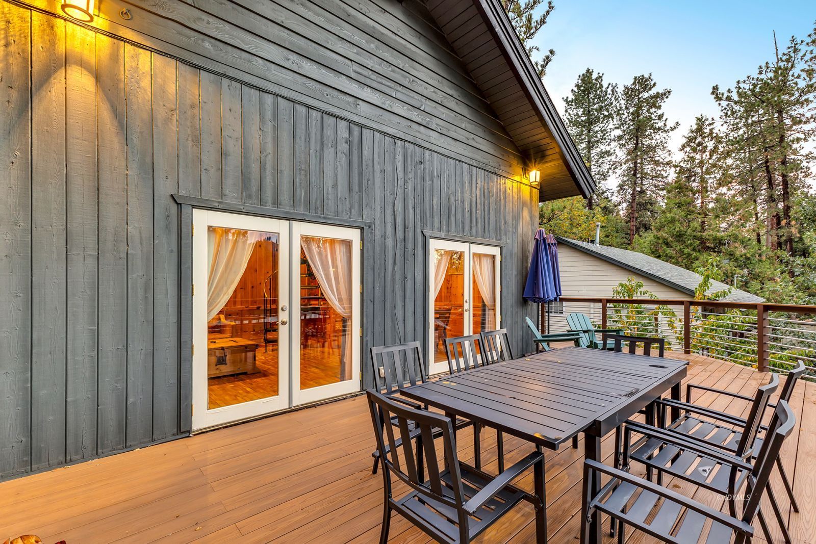 53560 Country Club Drive Idyllwild, CA 92549 - Photo 31 of 66 a view of a patio with table and chairs with wooden floor and fence