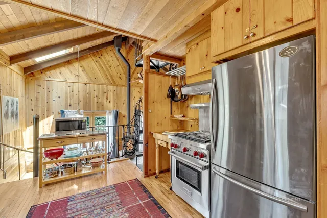 a kitchen with stainless steel appliances granite countertop a sink and a granite counter tops with wooden floors