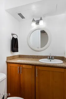 a bathroom with a granite countertop sink and a mirror