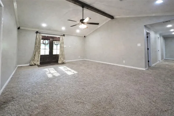 an empty room with windows and ceiling fan