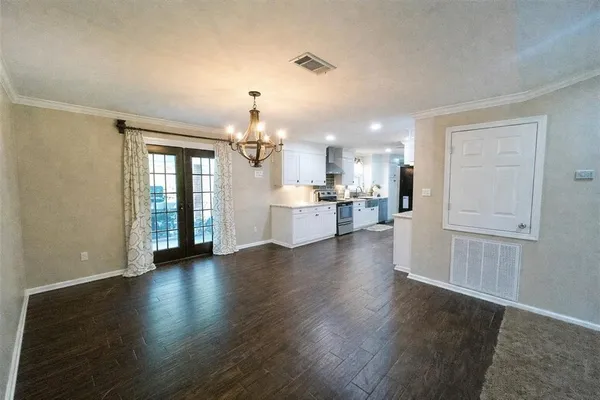 an open kitchen with a refrigerator and a stove top oven