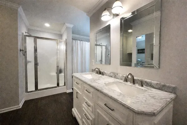 a bathroom with a granite countertop sink a large mirror and a shower