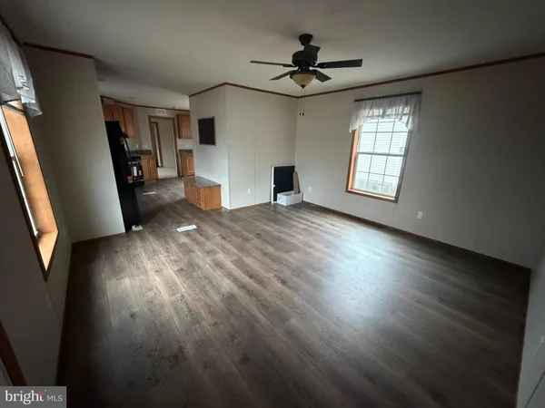 a view of a livingroom with wooden floor and a ceiling fan