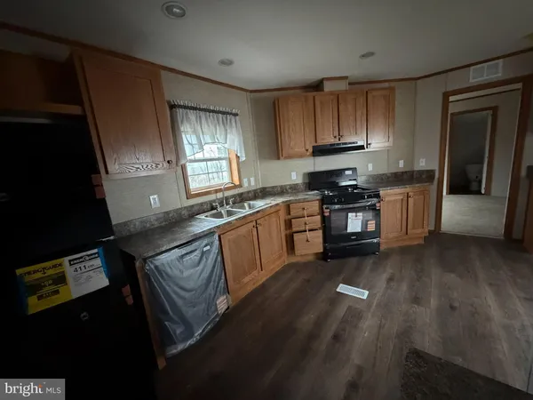 a kitchen with granite countertop stainless steel appliances sink stove microwave and cabinets
