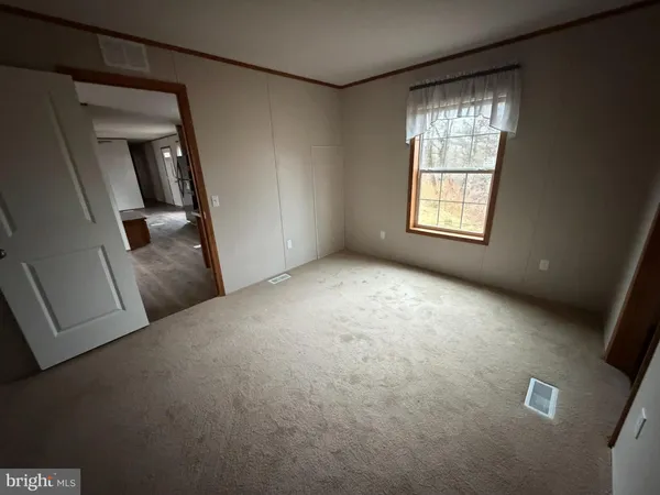 an empty room with windows and cabinet