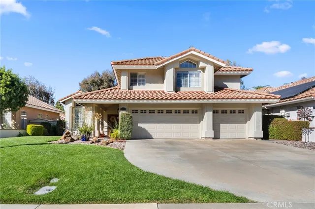 a view of a house with a yard potted plants and a large tree