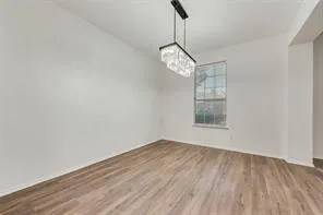 a view of a room with a window and wooden floor