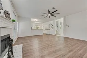 a view of an empty room with wooden floor and a fireplace