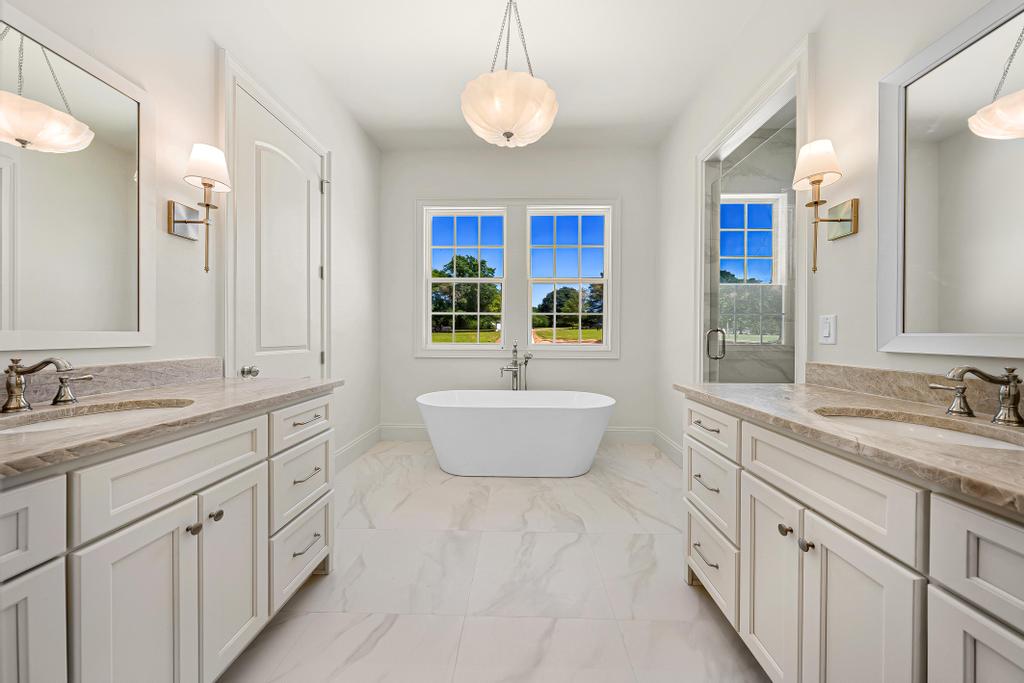 707 Vickery Street Extension Hartwell, GA 30643 - Photo 20 of 50 Dual vanities flank a tranquil soaking tub in this generously proportioned primary bathroom.