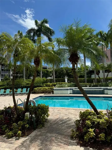 a view of swimming pool with lawn chairs and plants