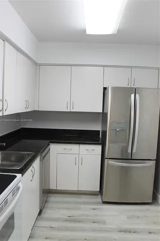 a kitchen with a sink and a refrigerator
