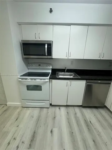 a kitchen with metallic refrigerator and cabinets