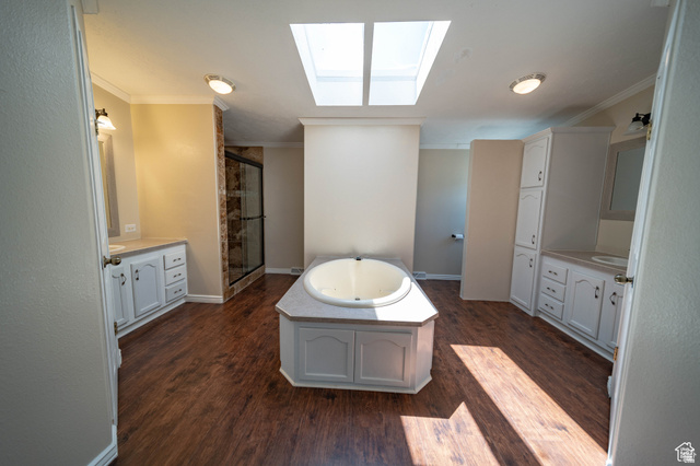 1407 North 1250th Street West Helper, UT 84526 - Photo 16 of 27 Full Master bath featuring a skylight, ornamental molding, a jetted tub, dark wood-type flooring, and a shower stall