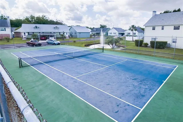 a view of a tennis ground with a large building