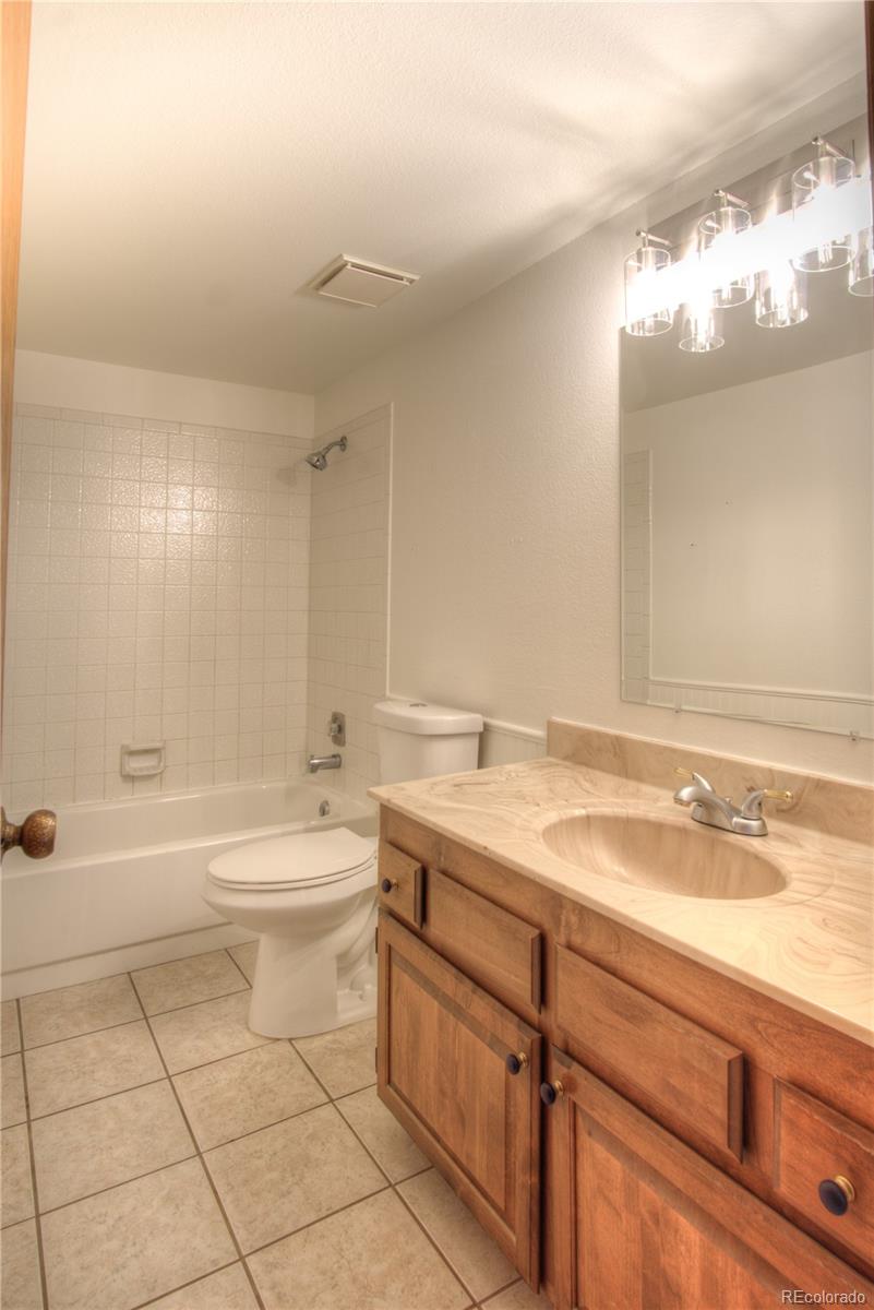 10385 East Red Mountain Road Littleton, CO 80127 - Photo 23 of 47 a bathroom with a bathtub a sink a toilet and a mirror