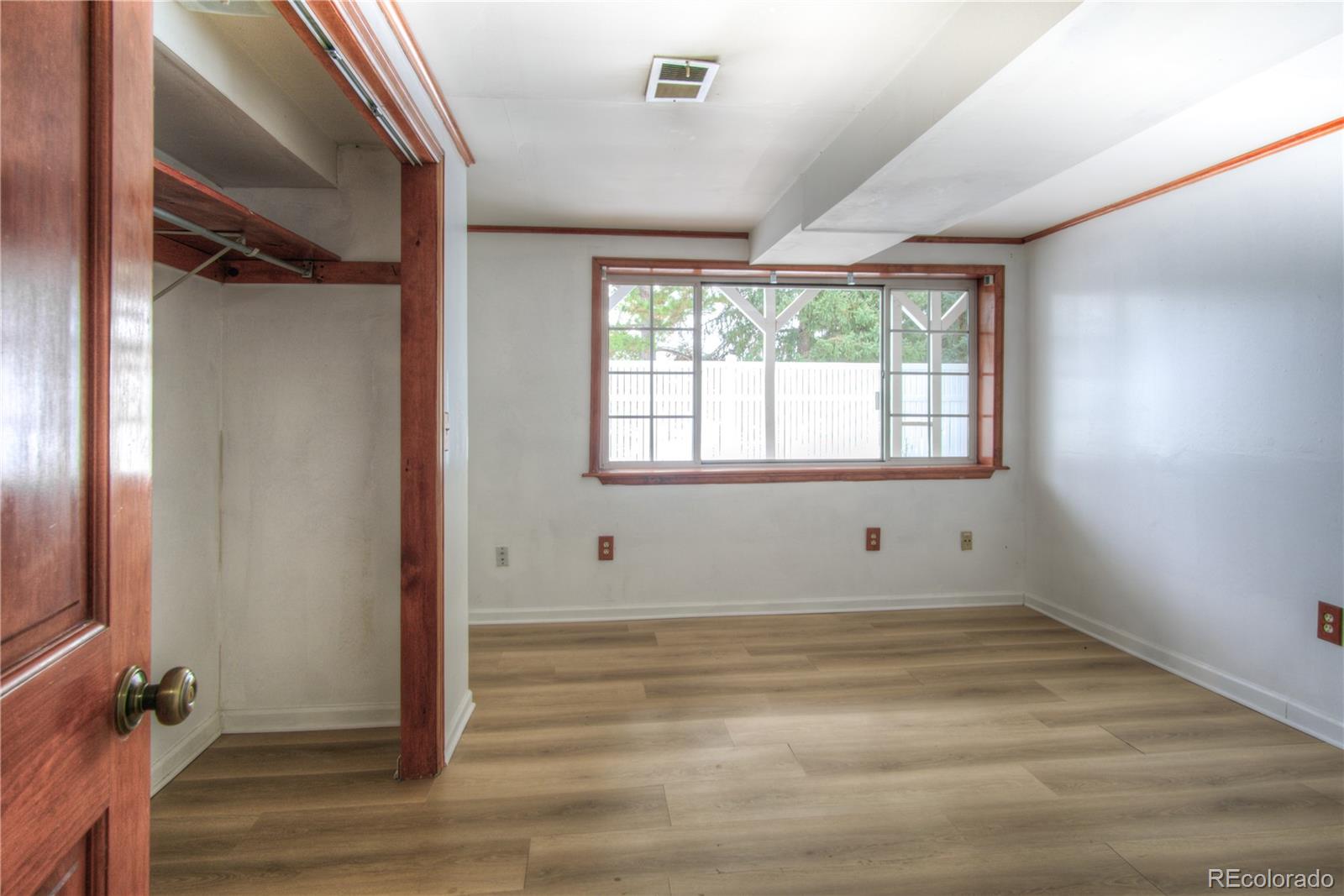 10385 East Red Mountain Road Littleton, CO 80127 - Photo 29 of 47 an empty room with wooden floor and windows