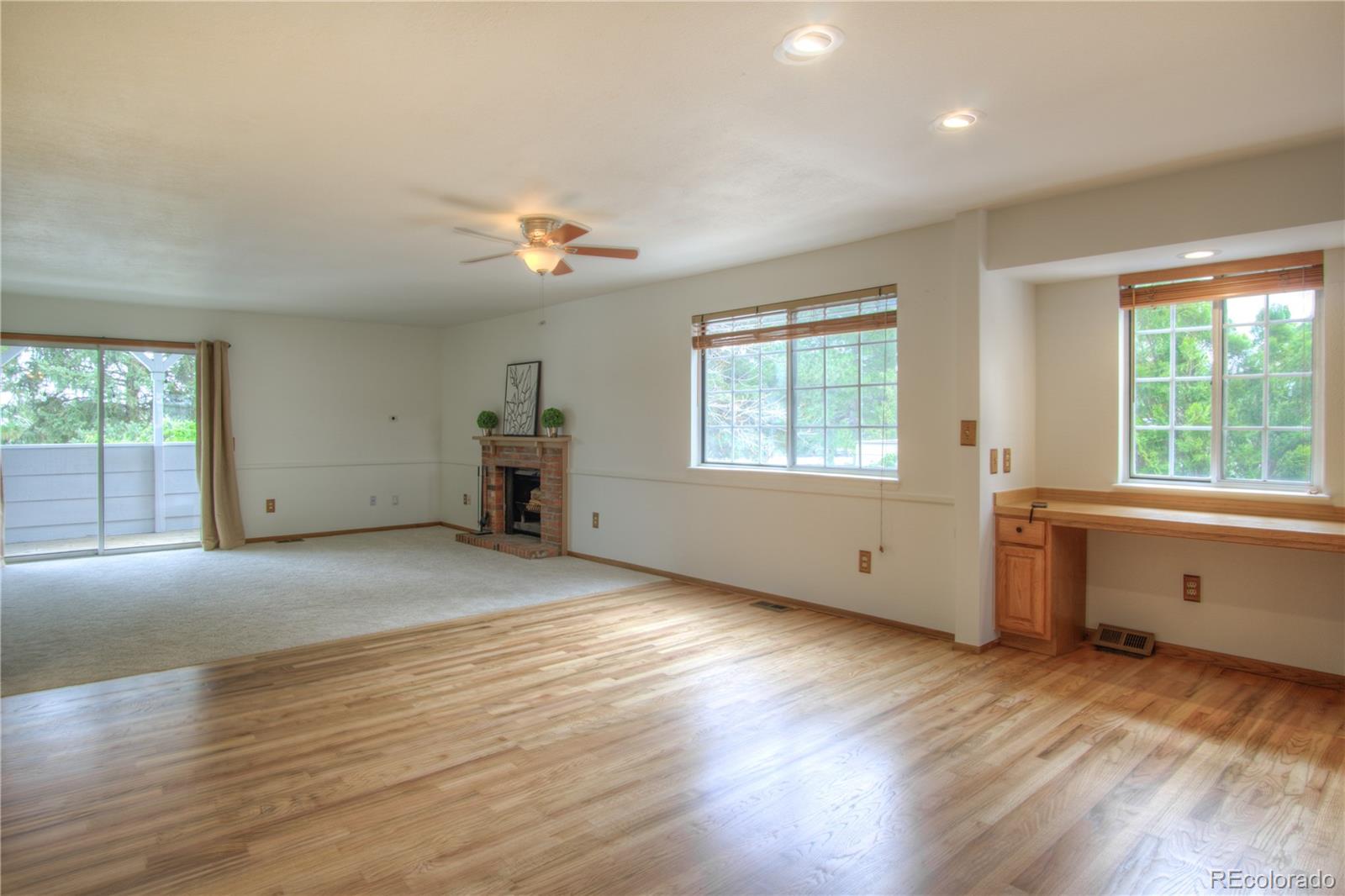 10385 East Red Mountain Road Littleton, CO 80127 - Photo 4 of 47 a view of an empty room with a window and wooden floor