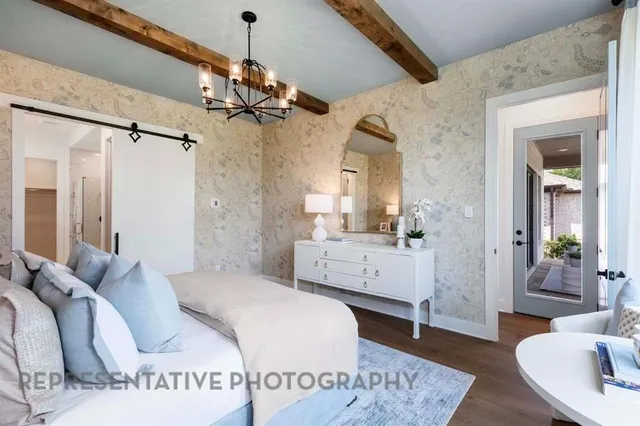a spacious bedroom with a bed a chandelier and mirror