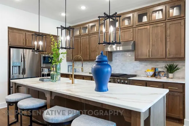 a kitchen with stainless steel appliances granite countertop a sink refrigerator and cabinets