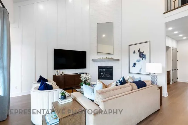 a living room with furniture a flat screen tv and a fireplace