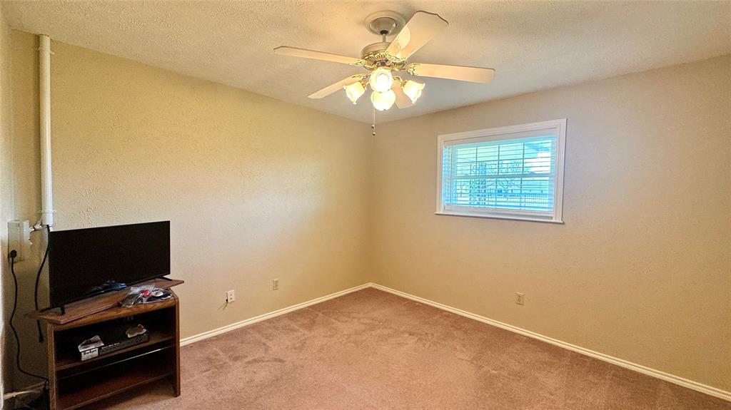 2050 Griffith Avenue Terrell, TX 75160 - Photo 14 of 27 en empty room with windows and ceiling fan