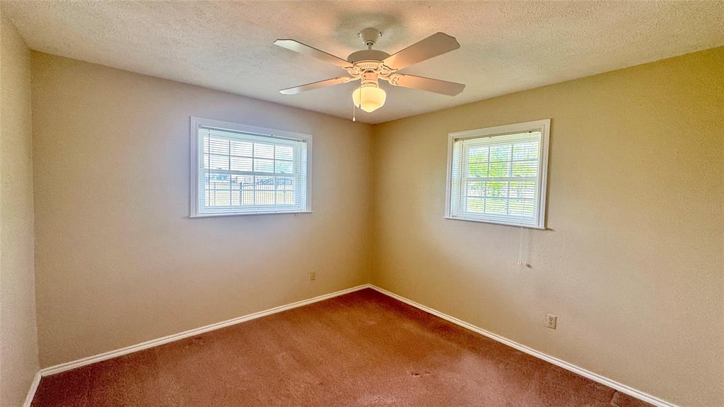 2050 Griffith Avenue Terrell, TX 75160 - Photo 15 of 27 an empty room with windows and ceiling fan