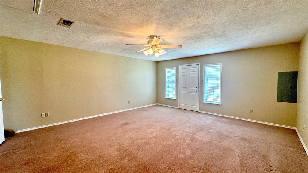 2050 Griffith Avenue Terrell, TX 75160 - Photo 10 of 27 en empty room with windows and chandelier fan