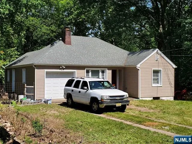 a white house covered with tall trees