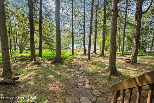 a backyard of a house with lots of green space and fountain