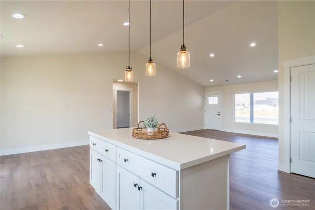 a kitchen with a sink chandelier and wooden floor
