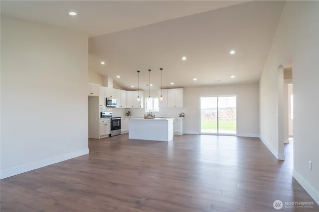 a view of kitchen with kitchen island sink refrigerator and window