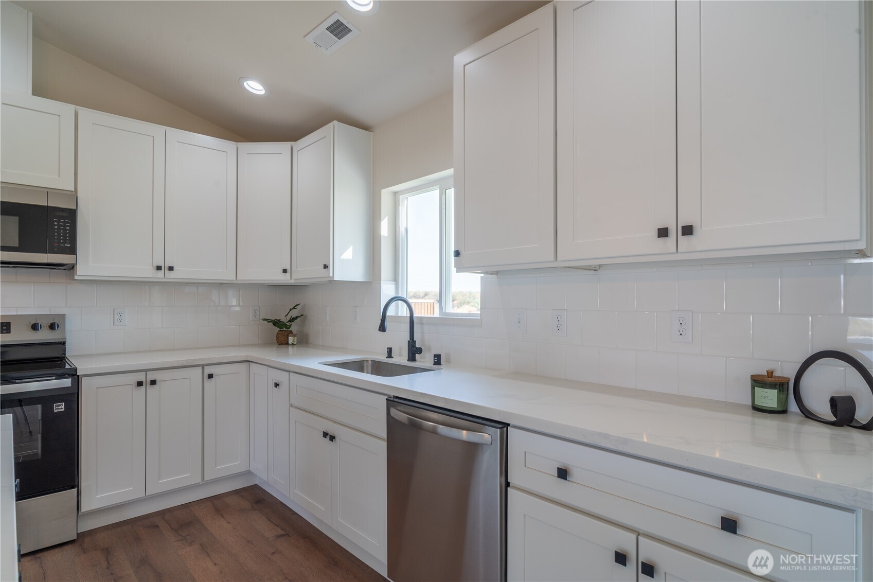 70 Sunwest Drive Ephrata, WA 98823 - Photo 9 of 34 a kitchen with a sink dishwasher and white cabinets with wooden floor