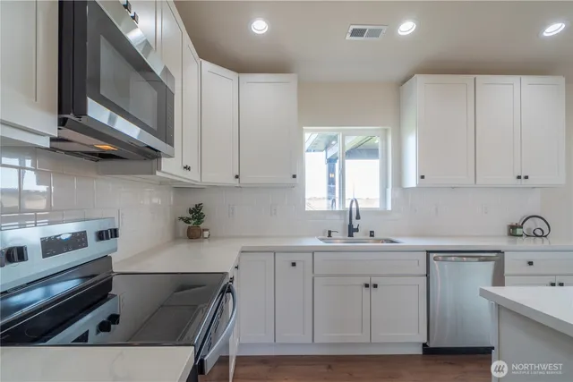 a kitchen with a sink cabinets and appliances