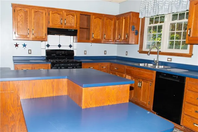 a kitchen with stainless steel appliances a sink stove and cabinets