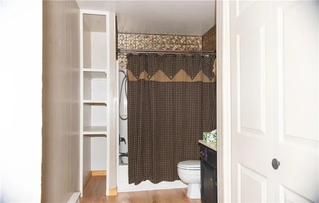 a bathroom with a toilet and a shower