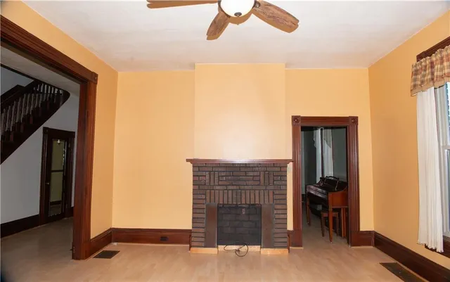 a view of hall way with wooden floor and a bathroom
