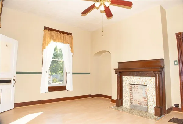 a view of empty room with a window and kitchen view
