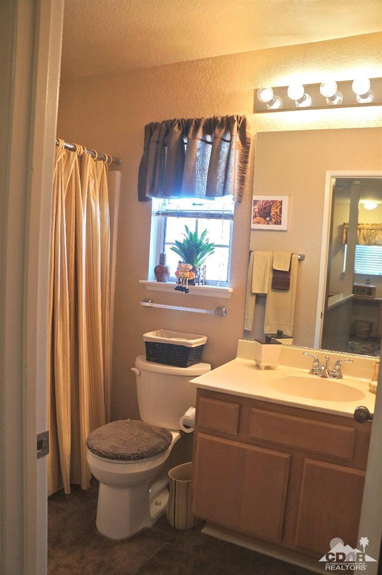 80928 Rio Grande Avenue Indio, CA 92201 - Photo 18 of 25 a bathroom with a toilet a sink and a mirror