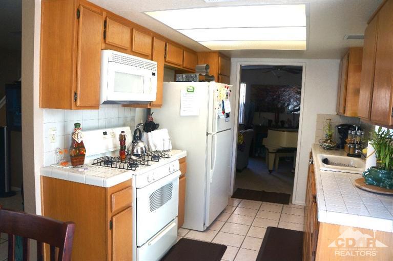 80928 Rio Grande Avenue Indio, CA 92201 - Photo 5 of 25 a kitchen with a sink a refrigerator a stove a washer and dryer